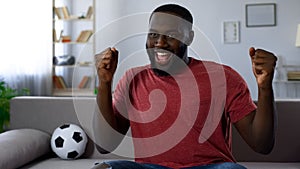 Victory of favourite football team, african-american man dancing victoriously