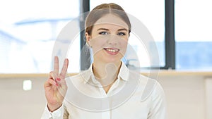 Victory gesture, woman in office