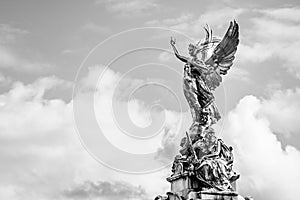 Victory Goddess golden statue on top of the Victoria Memorial located in front of Buckingham Palace with empty sky background for