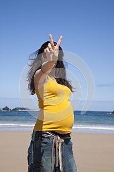 Victory pregnant woman at beach