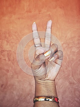 Victory sign on brown background