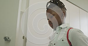 Video of african american boy closing locker and smiling at school