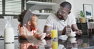 Video of african american father and daughter preparing breakfast