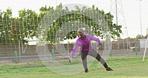 Video of african american goalkeeper on field, playing football