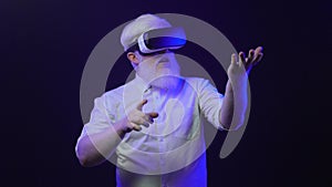 Video of an albino grandfather putting on a new vr set and making different hand gestures, isolated on a cool, unique background