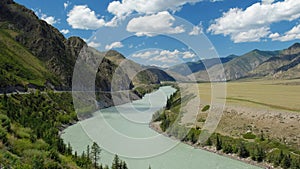 Video of Altai natural landscape with river Katun under blue sky with clouds. On the left bank of the river there is Chuya Highway