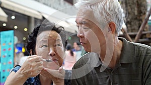 Video Asian senior couple eating an ice cream and feed each other abstract eternal love