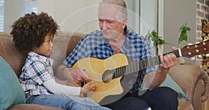 Video of biracial grandson and caucasian grandfather playing the guitar together
