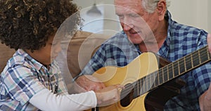 Video of biracial grandson and caucasian grandfather playing the guitar together