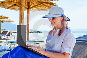 Video blogger, freelancer editing video at beach. Editing Videos On Laptop Using Video Editor App.