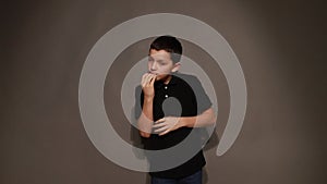 Video of Boy teenager shows trick with cookies. Hobbies for children, adolescents