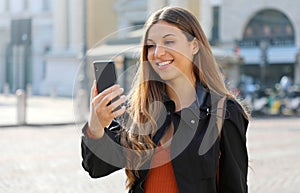 Video Call. Transfer student using phone for internet call in city street photo