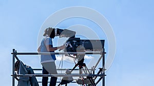 Video camera operator - man working and filming on set with his equipment