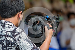 Video camera operator working with his equipment. video cinema production. Covering an event with a video camera. Professional vid