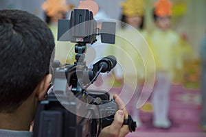 Video Camera recording kindergarder room with blurred background, copy space - Image . Video camera operator working with his