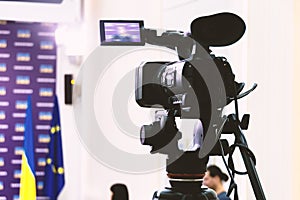 Video camera on a tripod at a press conference