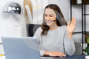 Video chat with young smiling woman wearing headset