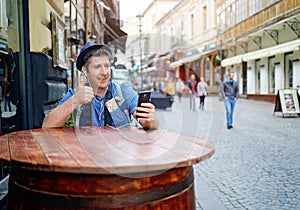 Video chatting on smart phone. Unrecognisable People walking behind on the street