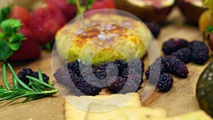 Video Cheese with strawberry, berries and fruits on wood platter