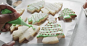 Video of christma cookies being decorated with green sugar icing with copy space on white background