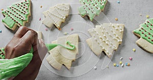 Video of christma cookies being decorated with green sugar icing with copy space on white background