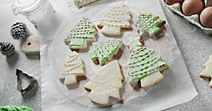 Video of christma cookies decorated with green sugar icing with copy space on white background