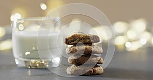 Video of christma cookies, glass of miljk and copy space on grey background