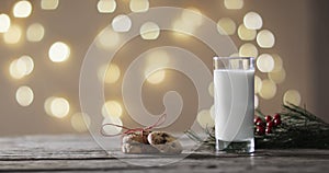 Video of christma cookies, glass of miljk and copy space on wooden background