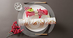 Video of christmas place setting with christmas cracker on grey background
