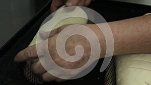 Video clip from the modern bakery. Cook slices raw dough. Preparation for baking French loaves