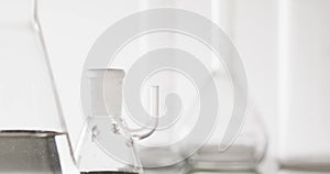 Video of close up of glass laboratory beakers and dishes with copy space on white background