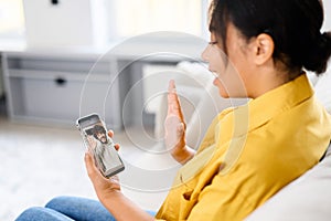 Video communication via smartphone. A young woman is using phone app for video call, online meeting. She talks with a