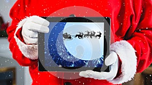 Video composition with snow over torso of santa holding tablet