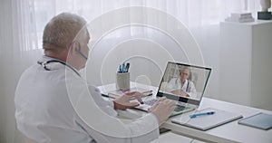 Video conference of two experienced medical specialists, men are chatting online and consulting each other