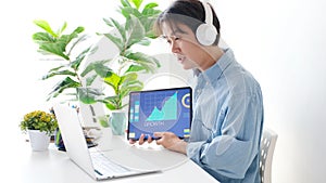 Video conference, Work from home, Asian man holding business chart on digital tablet while making video call to business team with