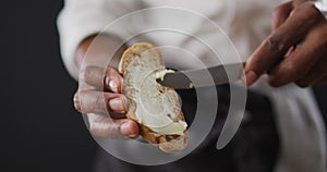 Video of cook grease bread with butter on black background