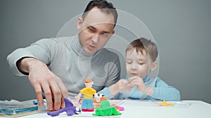 Video of dad and little boy making animals from plasticine