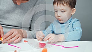 Video of dad and little boy making toys from plasticine