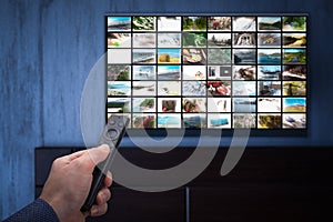 Video on demand service on smart TV. man choosing what to watch on TV at home. Video on demand or VOD. Online movie stream service