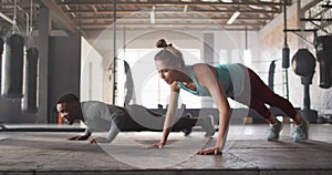 Video of diverse fit man and woman doing push ups at gym