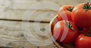 Video of fresh tomatoes in bowl with copy space over wooden background