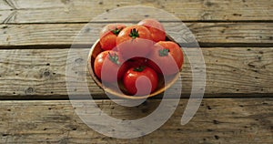 Video of fresh tomatoes in bowl over wooden background