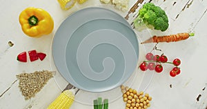 Video of fresh vegetables arranged around grey plate with copy space on white rustic background