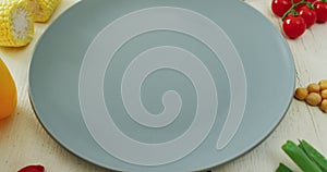 Video of fresh vegetables arranged around grey plate with copy space on white rustic background