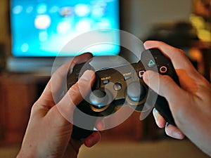 Video game console controller for gaming held in gamers hands.