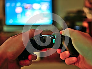 Video game console controller for gaming held in gamers hands.