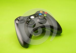 Video game control supported on a green background surface, selective focus