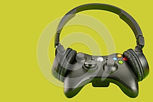 Video game controller using a headset on a green background surface, selective focus