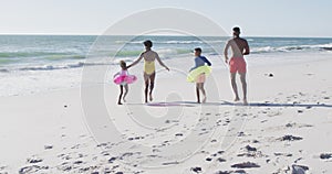 Video of happy african american family running on beach