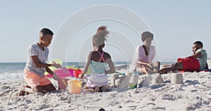 Video of happy african american kids and parents playing on beach